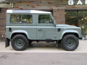 ランドローバー ディフェンダー 90SW 2.2Tdci ヘリテイジスタイル 本革張替 WolfStyle同色スチールホイール M/Tタイヤ 4人乗り AT換装済 Nox/Pm適合 3ナンバー ヘリテイジグリル ホワイトルーフ クリアレンズ フルカーペット施工 アルカンターラヘッドライナー フォールディングステップ 白ロゴマッドフラップ 背面タイヤ 並行輸入車 右ハンドル 記録簿付の中古車